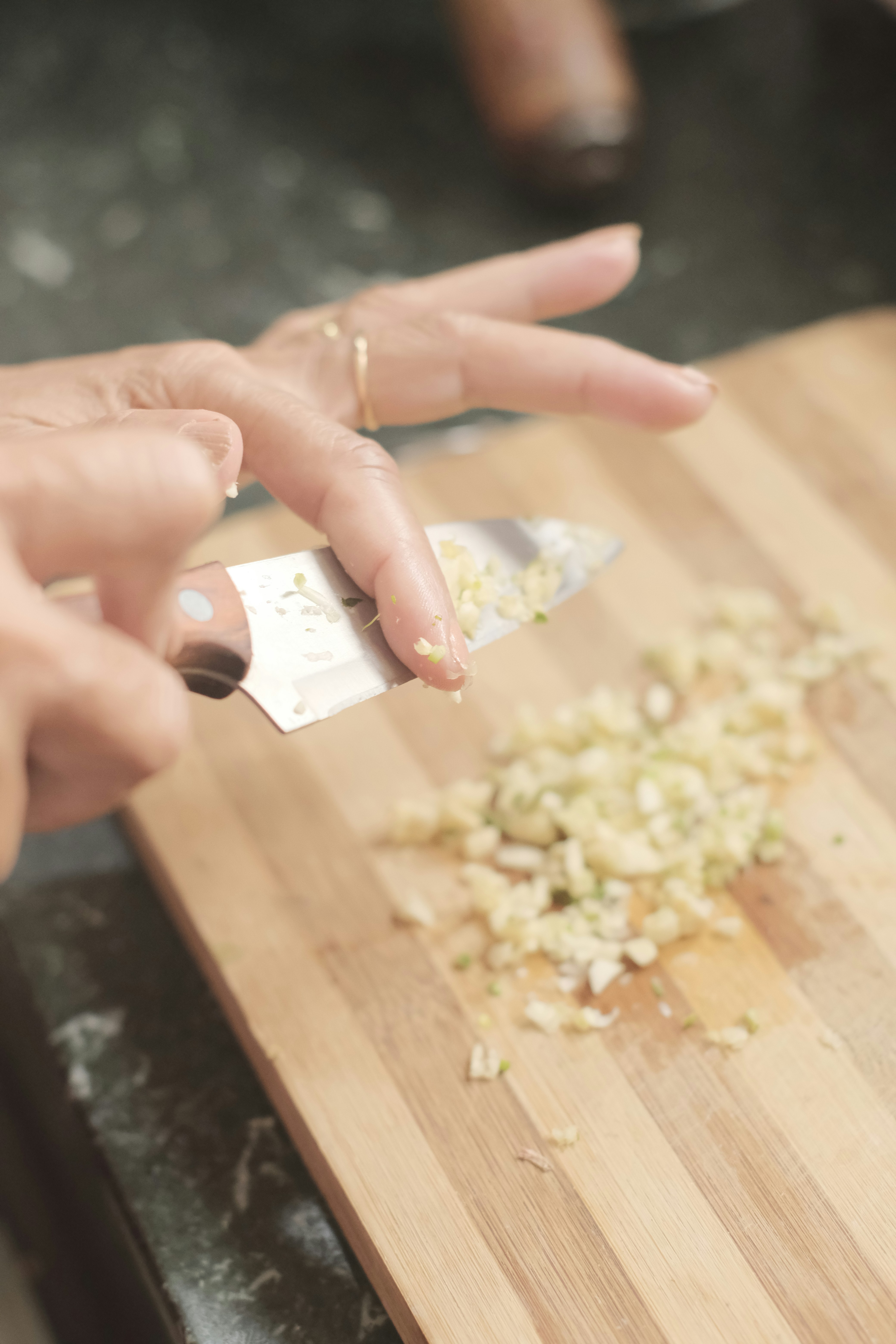 A woman chopping onions on a cutting board