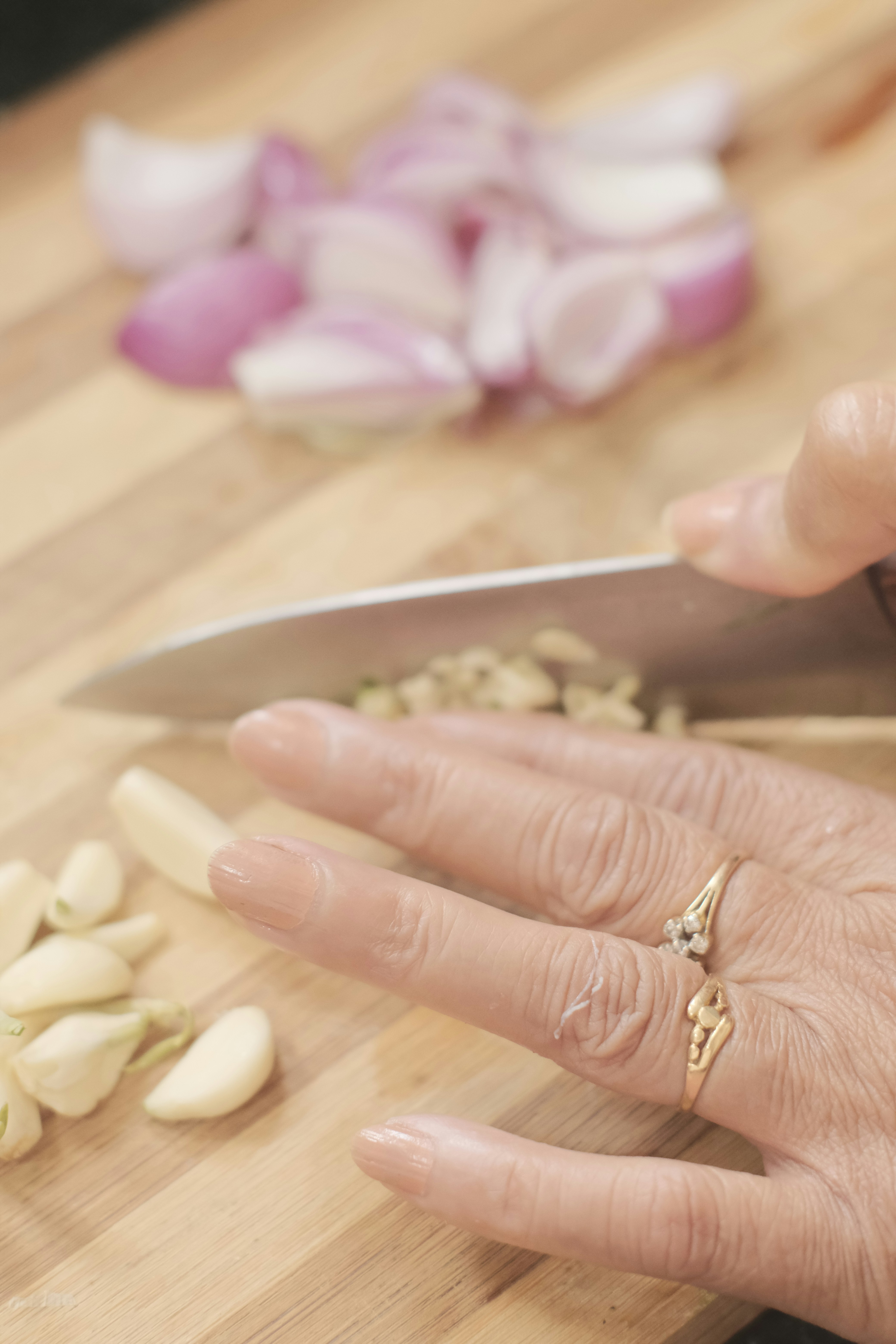 A woman chopping garlic on a cutting board