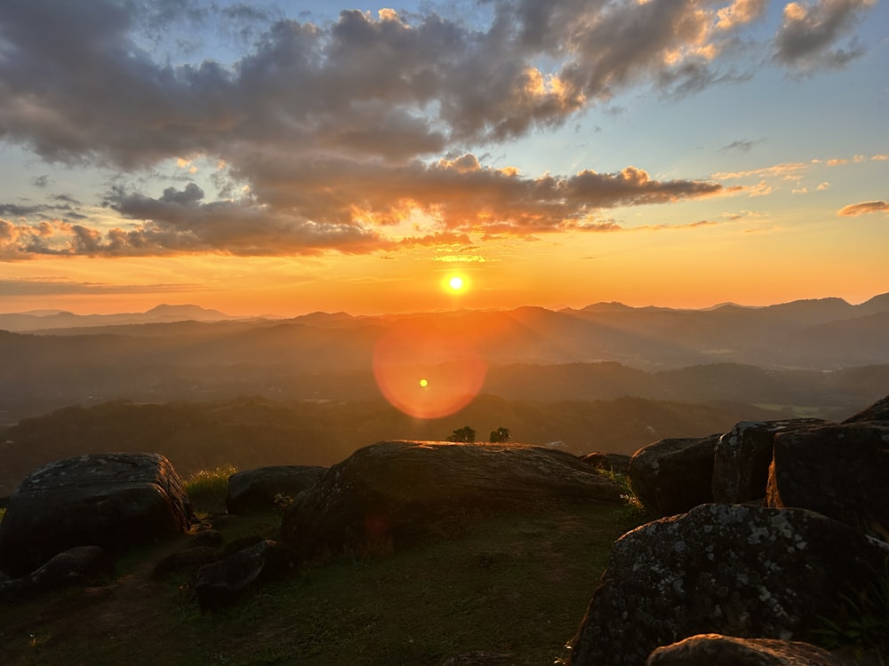 the sun is setting over a mountain range