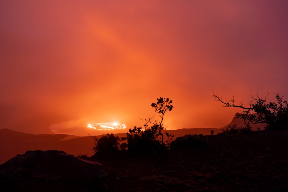 the sun is setting over a mountain range