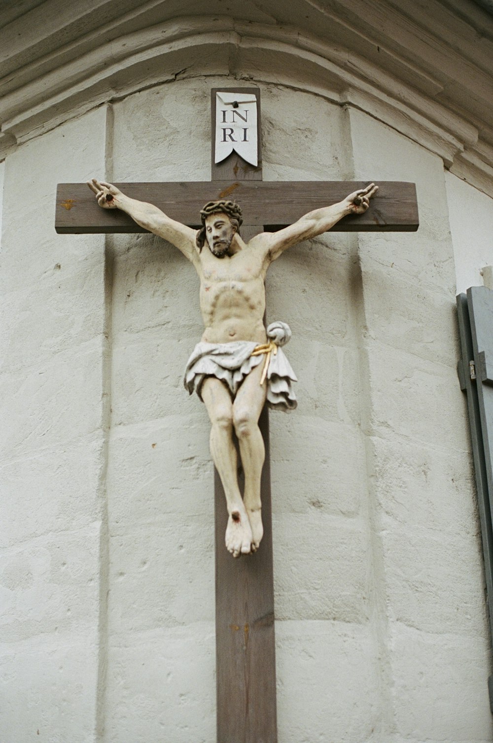 uma estátua de jesus em uma cruz de madeira
