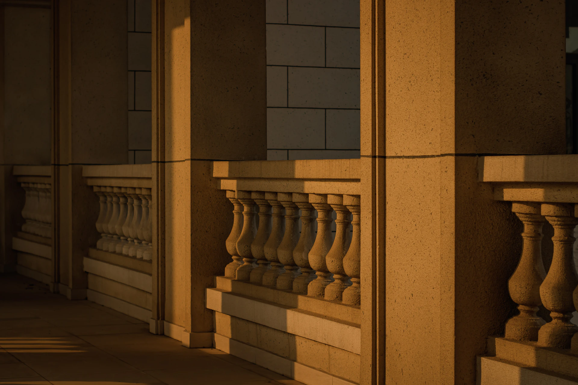 A close-up of elegant stone pier caps atop a garden wall, bathed in warm sunlight.