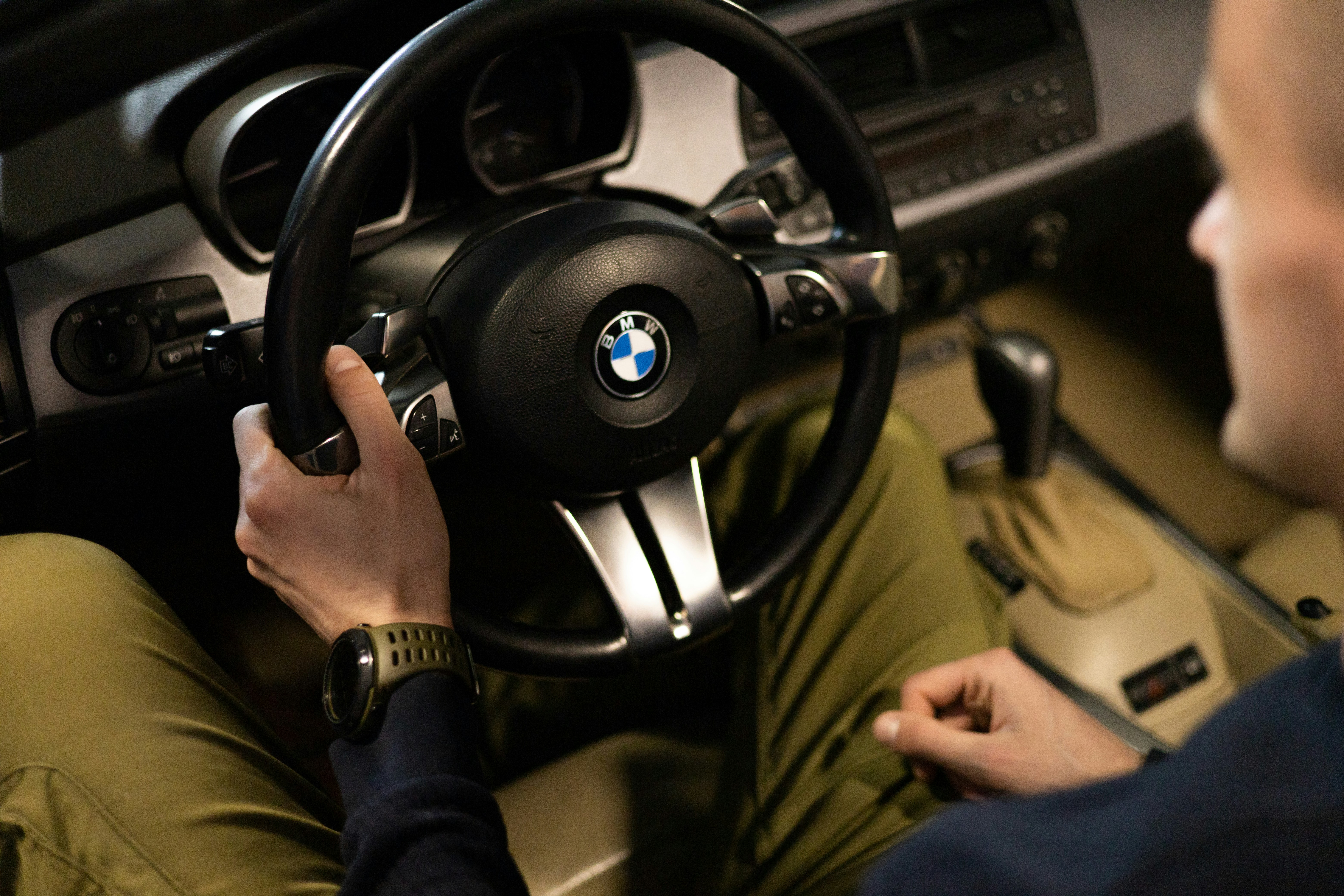 a man sitting in a car holding a steering wheel