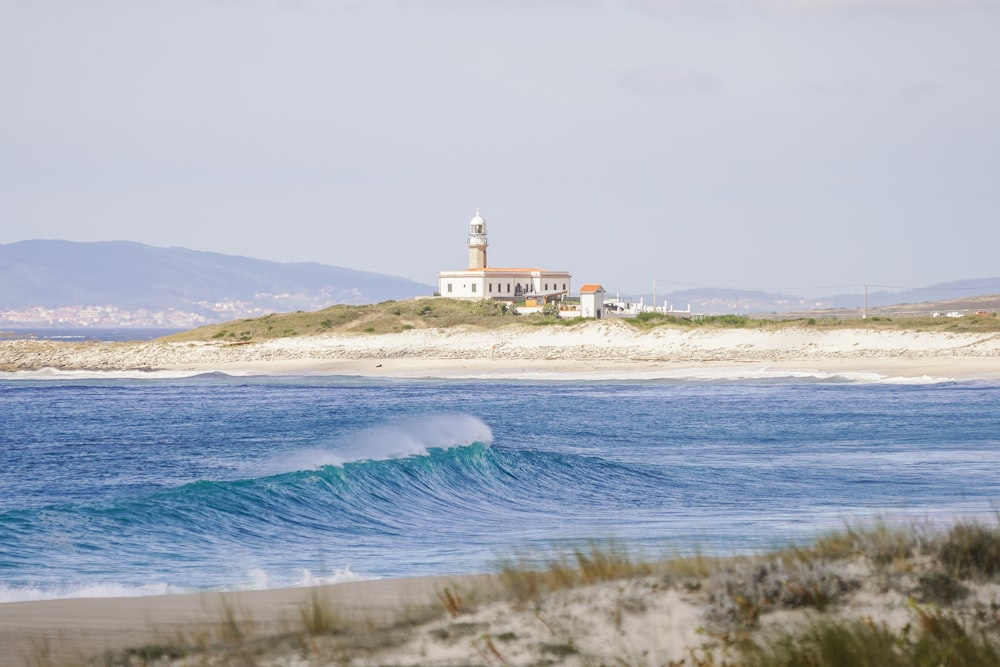 a lighthouse on top of a hill next to a body of water