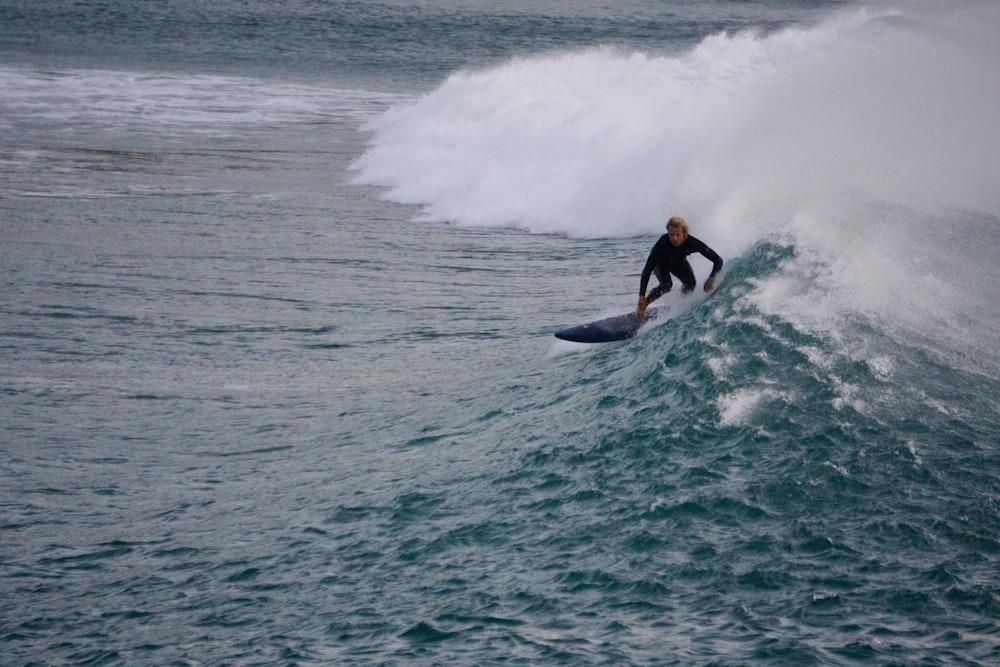 a man riding a wave on top of a surfboard