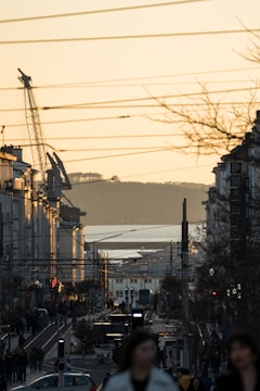 Construction workers installing lighting systems on a busy city street at dusk
