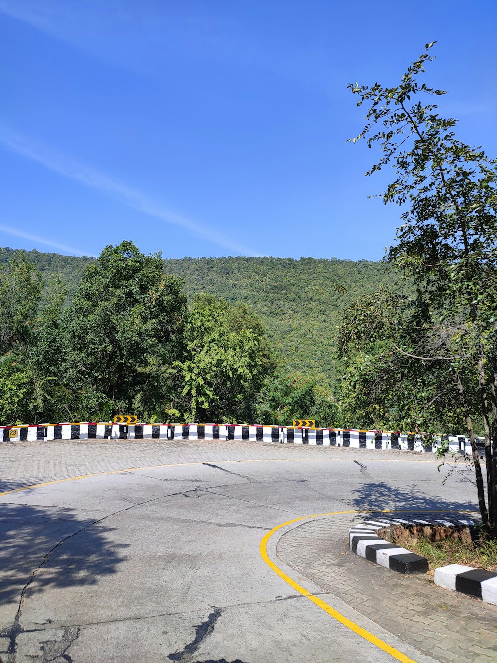an empty parking lot surrounded by trees and hills