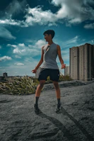 A joyful person applying shea butter outdoors with city buildings behind them.