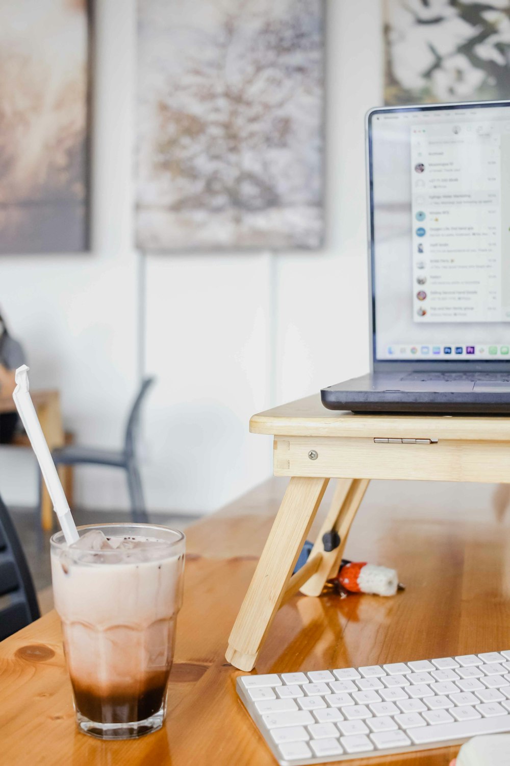 a glass of liquid next to a laptop on a table