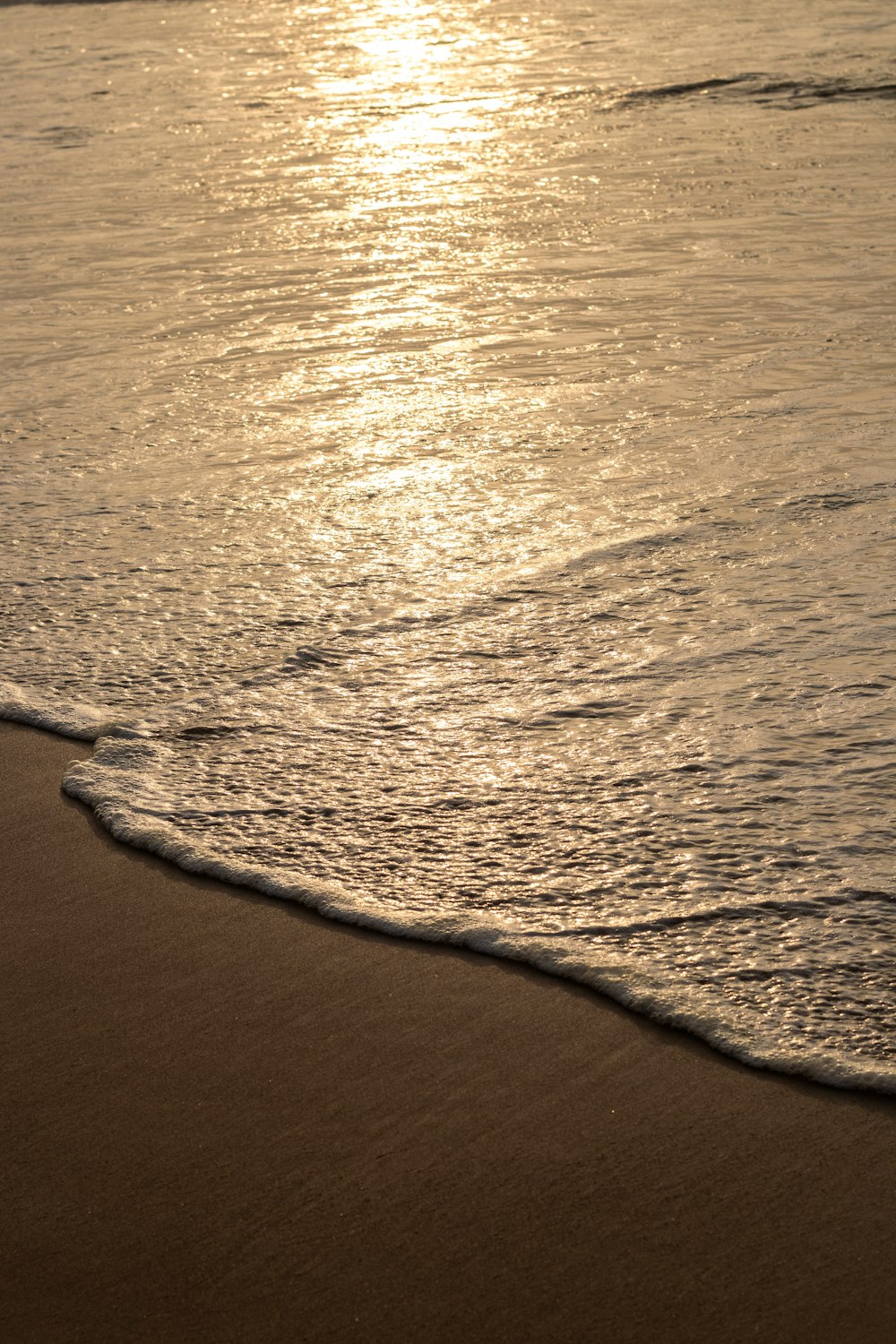 a person walking on the beach with a surfboard