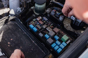 a person is working on a car's engine compartment