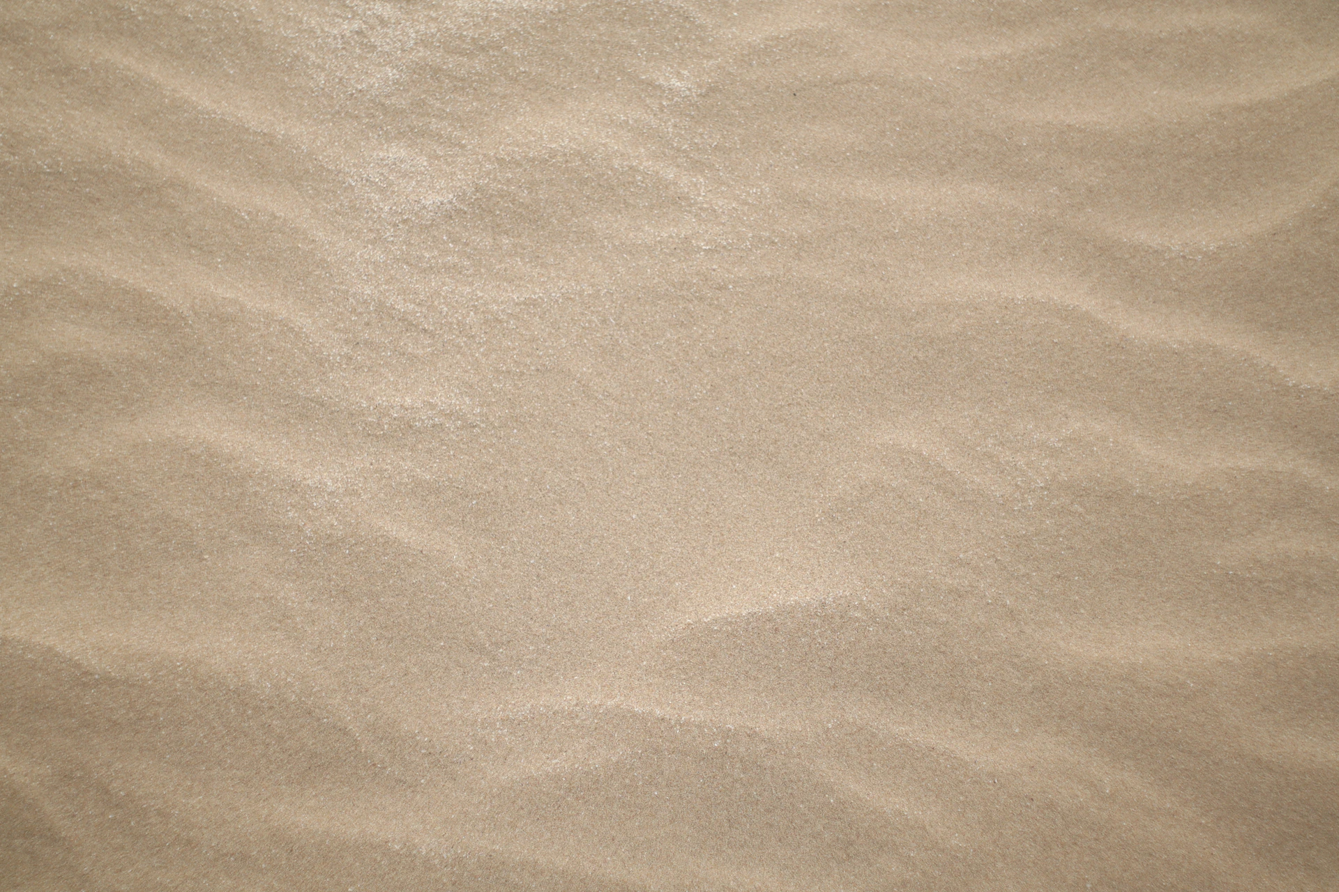 a sandy beach with a small wave in the sand