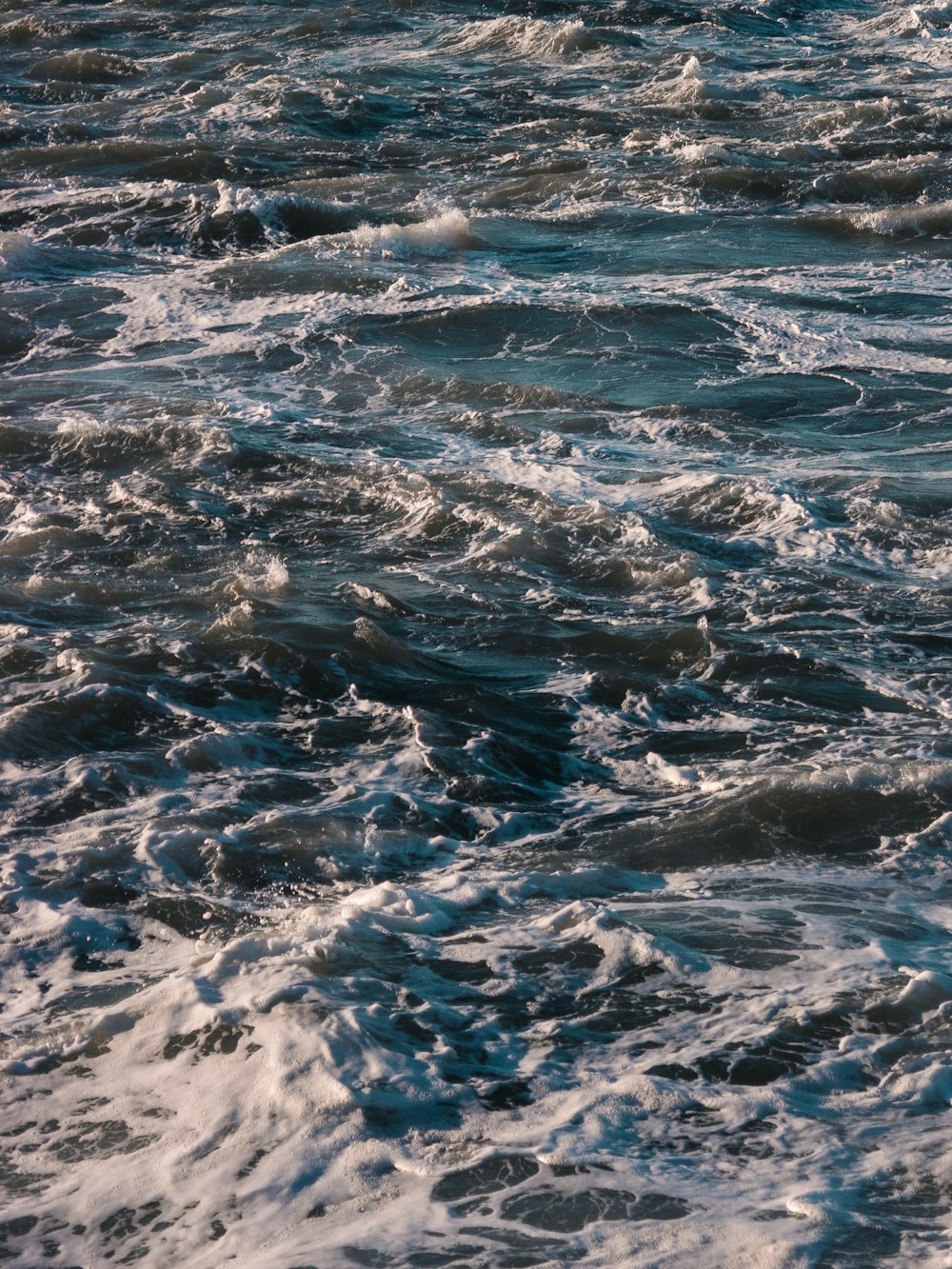 a man riding a surfboard on top of a wave covered ocean