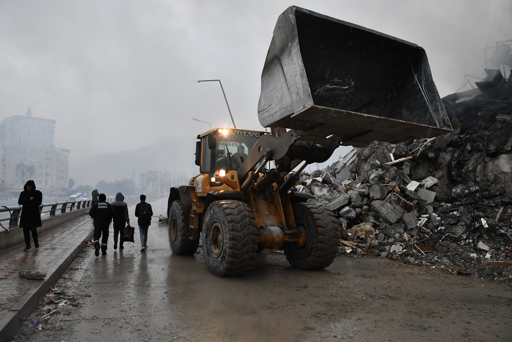 a bulldozer is parked in front of a pile of rubble