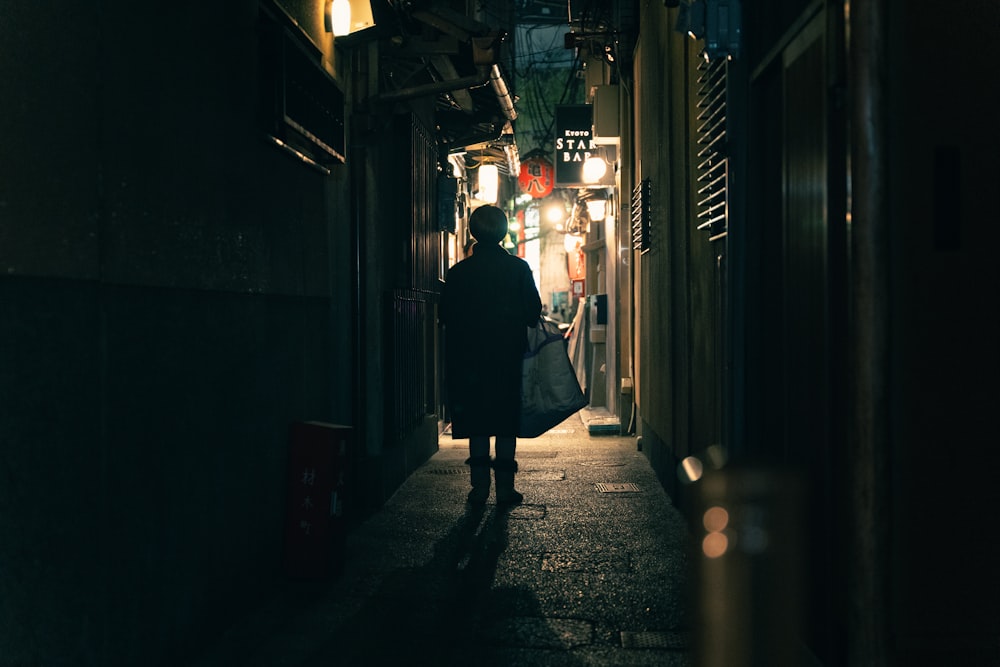 a person walking down a dark alley way