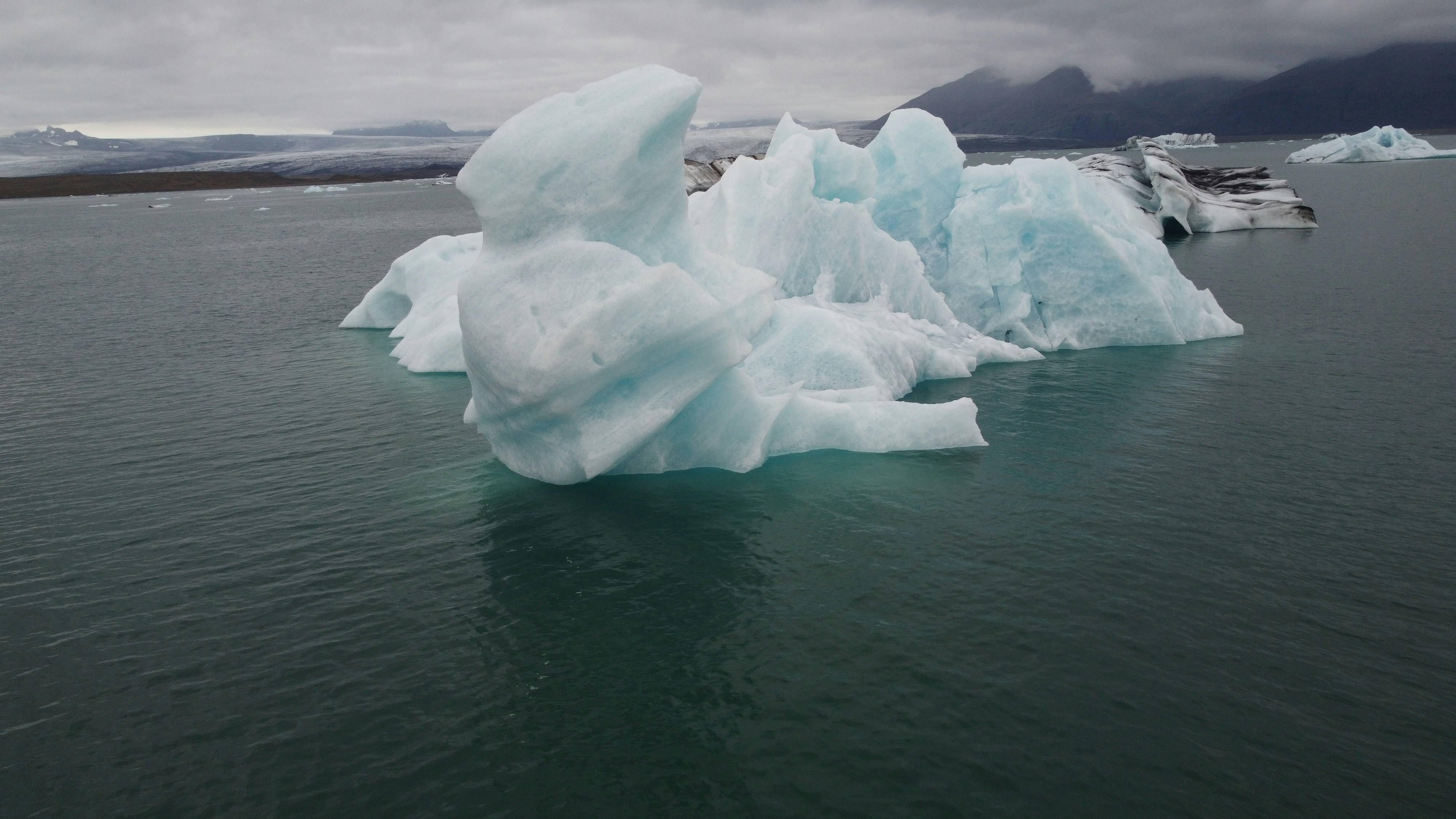 a group of icebergs floating on top of a body of water