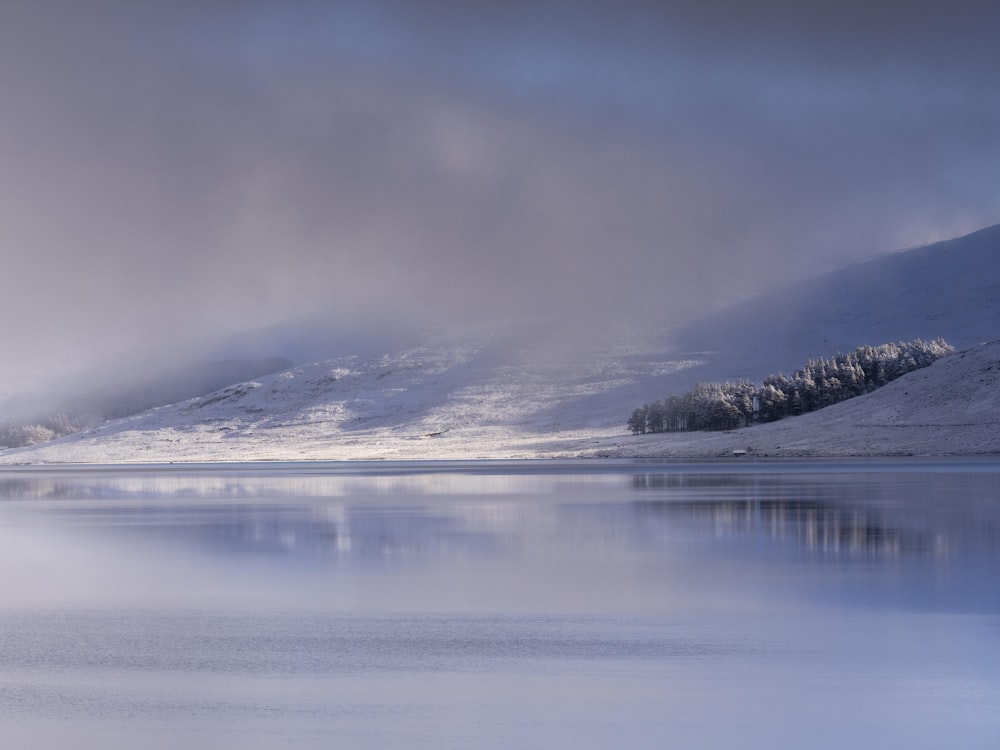 a large body of water surrounded by snow covered mountains