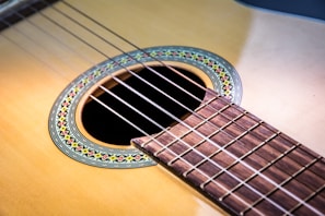 Close-up of a polished acoustic guitar with warm wood tones and intricate rosette detail