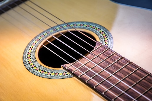 Close-up of a handcrafted classical guitar's wood grain and intricate rosette design.