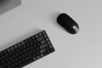 a computer keyboard and mouse on a desk