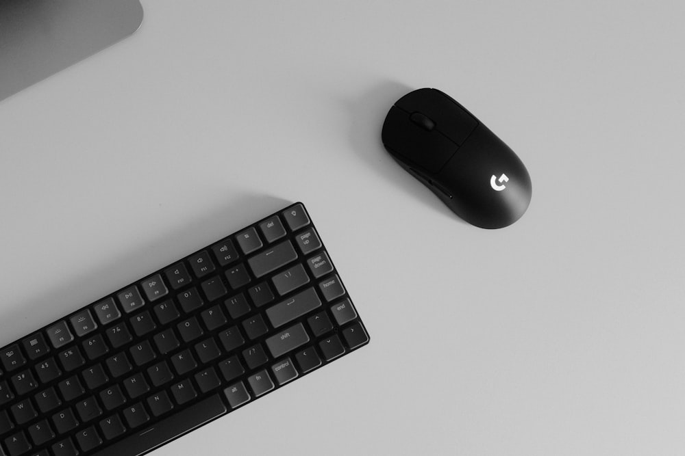 a computer keyboard and mouse on a desk