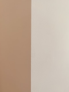 Close-up of a smooth, flawless beige wall corner with perfect paint finish in a modern León residence