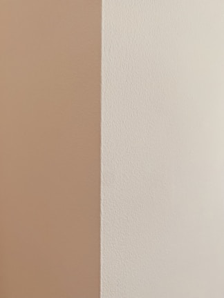 Before and after shot of a patched and painted drywall corner in a home.