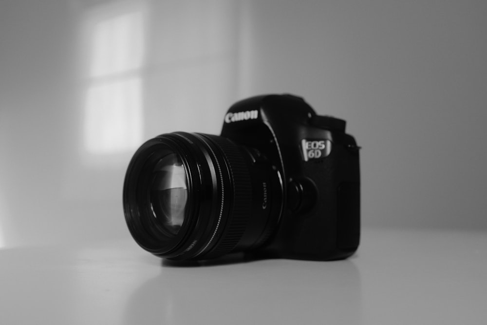 a black camera sitting on top of a white table