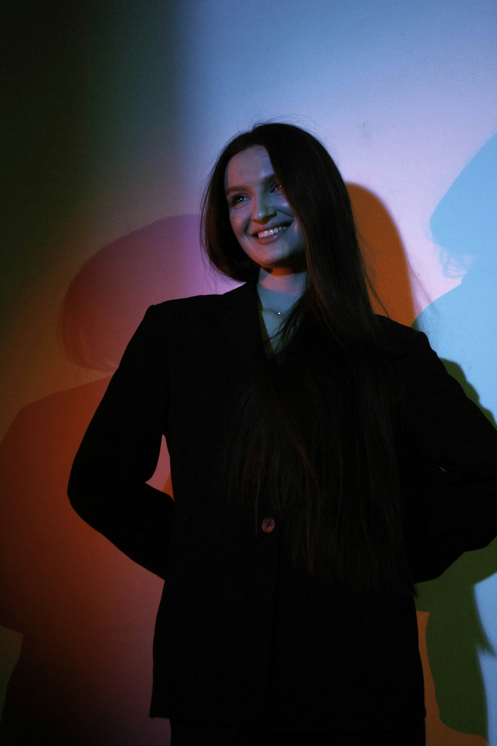 a woman standing in front of a wall with her hands on her hips