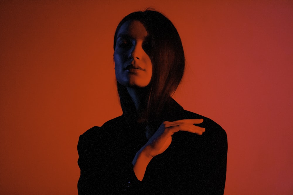 a woman in a black shirt is holding her hand up