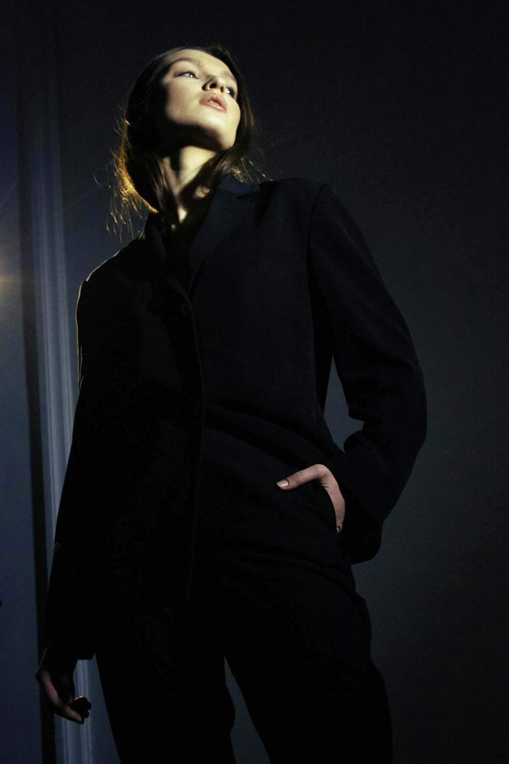 a woman standing in a dark room with her eyes closed