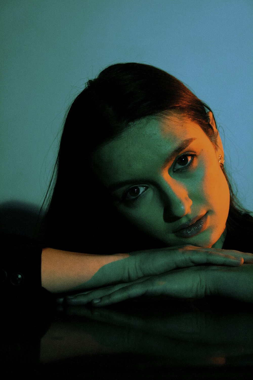 a woman sitting at a table with her hands on her chest