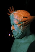 a statue of a man with his hands on his head