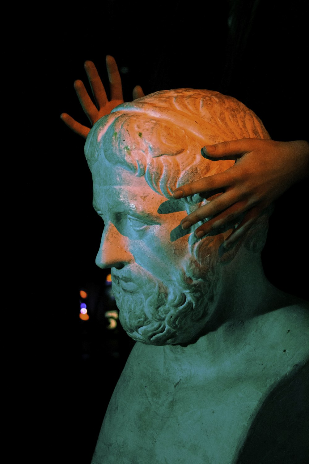 a statue of a man with his hands on his head