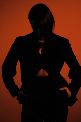 a silhouette of a woman with her hands on her hips