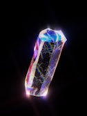 A mystical crystal embedded in a wooden staff, radiating vibrant colors.