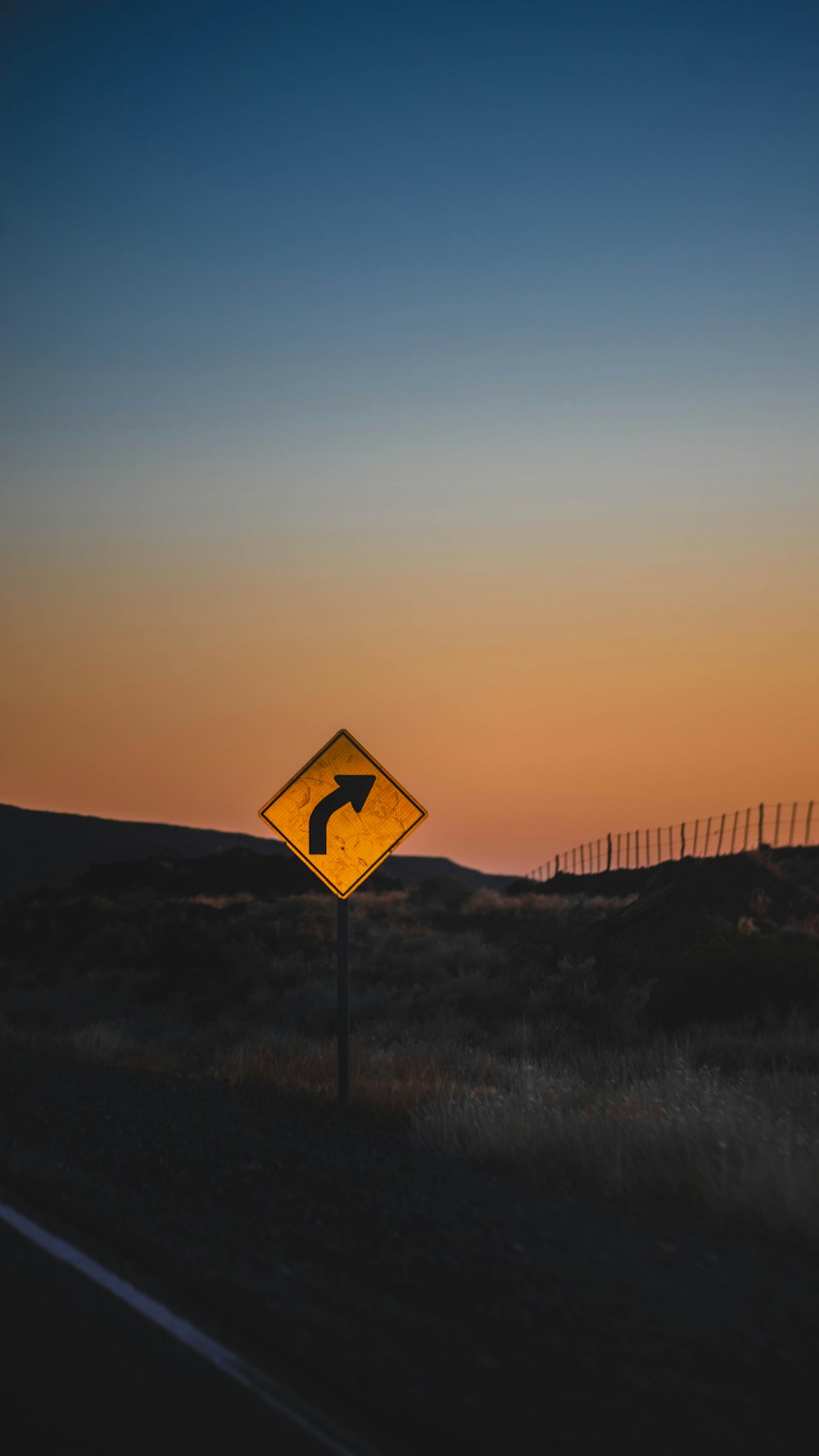 a yellow road sign sitting on the side of a road