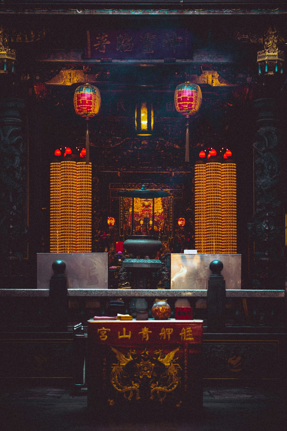 a large room with a red table and two red lanterns