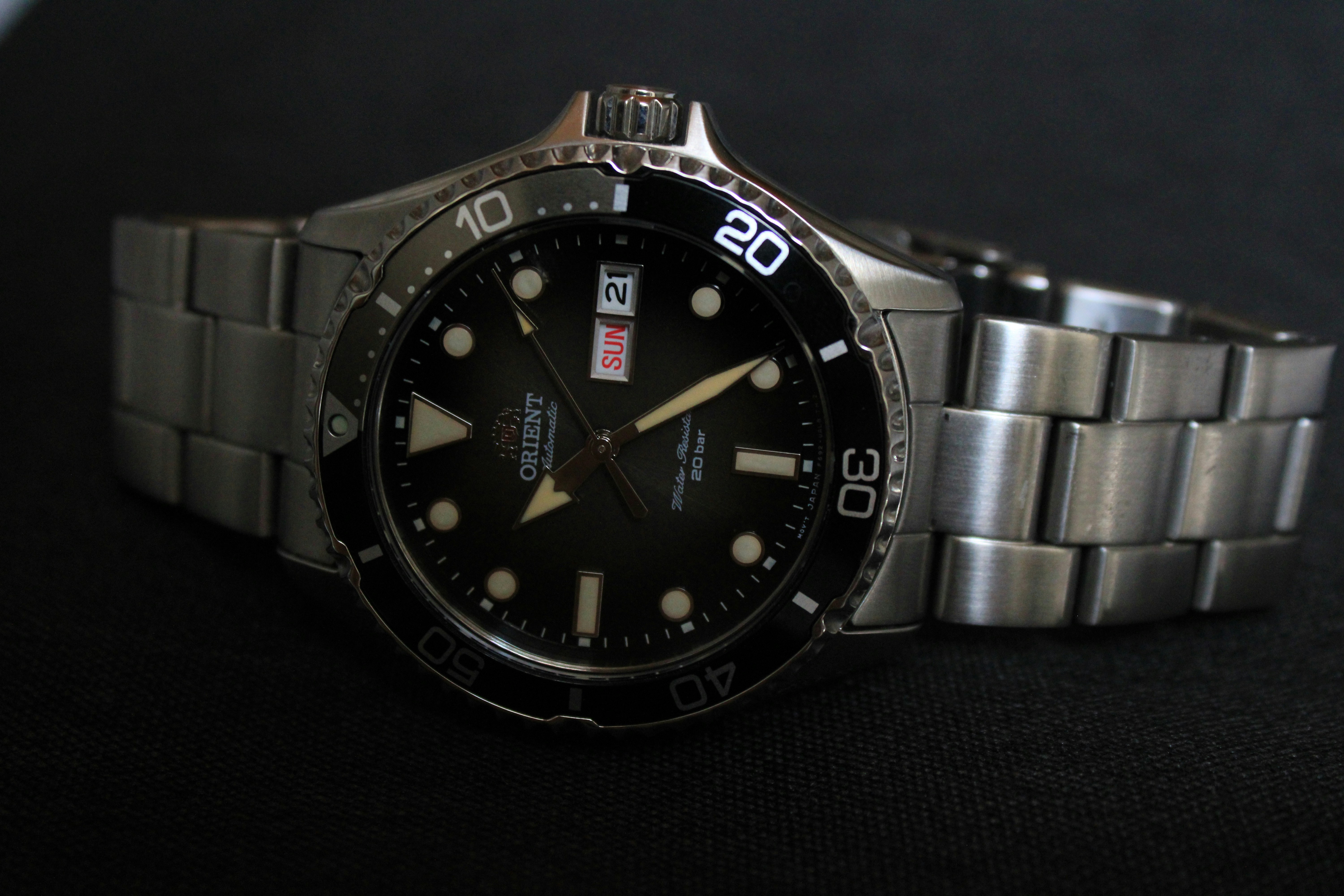 Un reloj sentado encima de un brazalete de metal