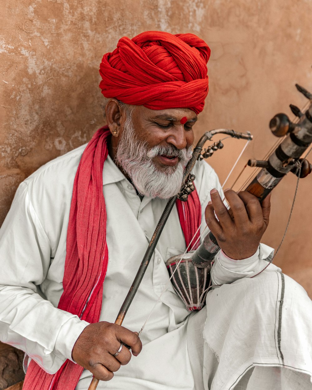 a man with a red turban playing a musical instrument