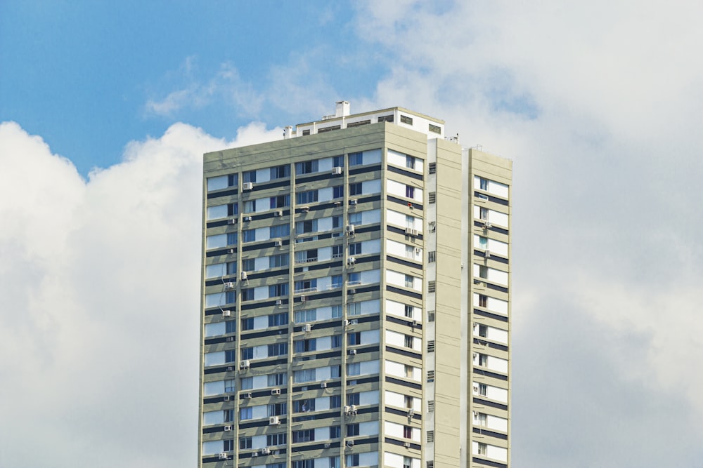 a tall building with windows and a sky background