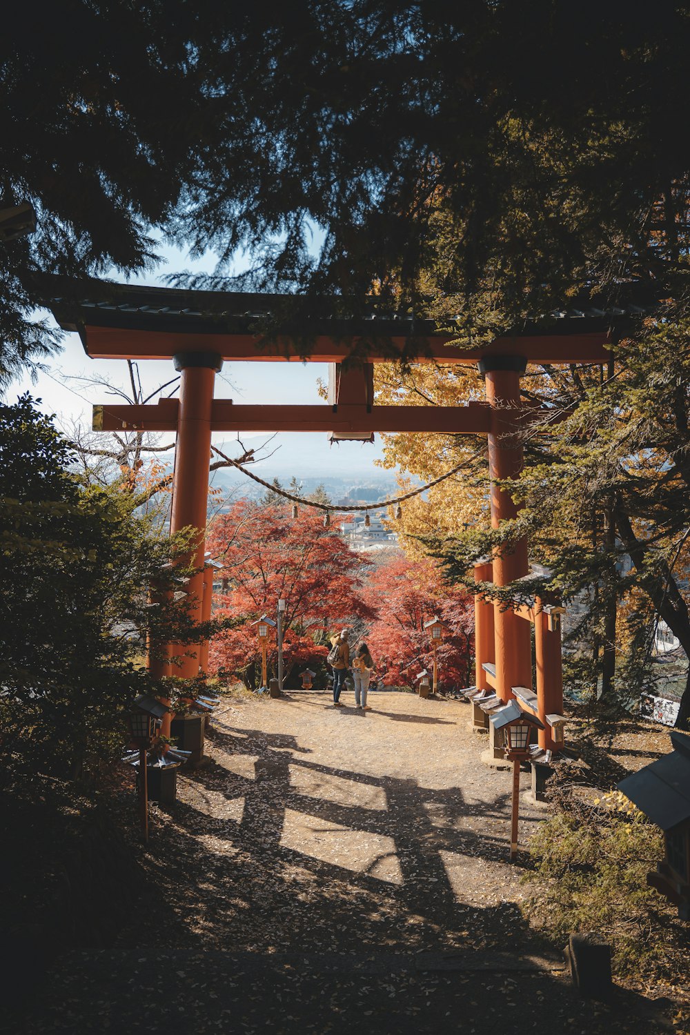 a couple of people walking under a tall wooden structure