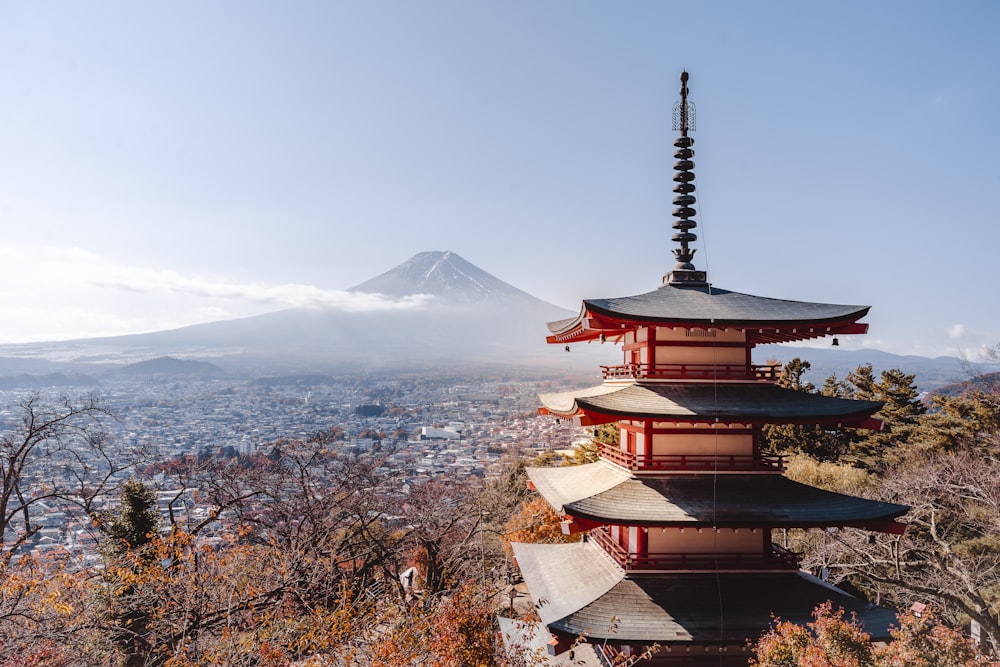 a tall pagoda with a mountain in the background