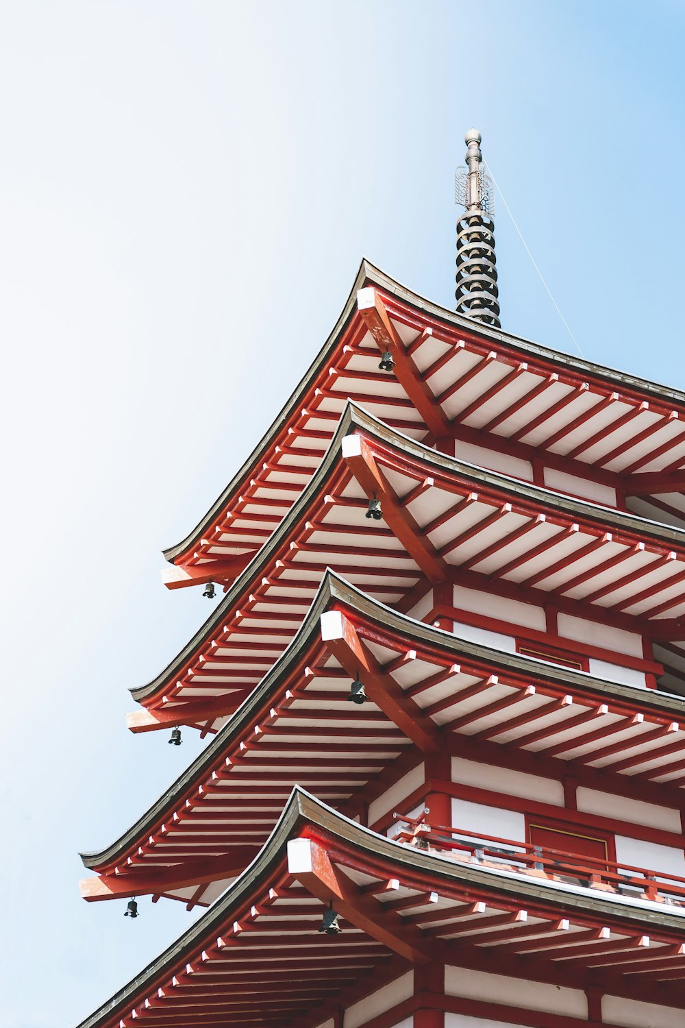 a tall red and white building with a sky background