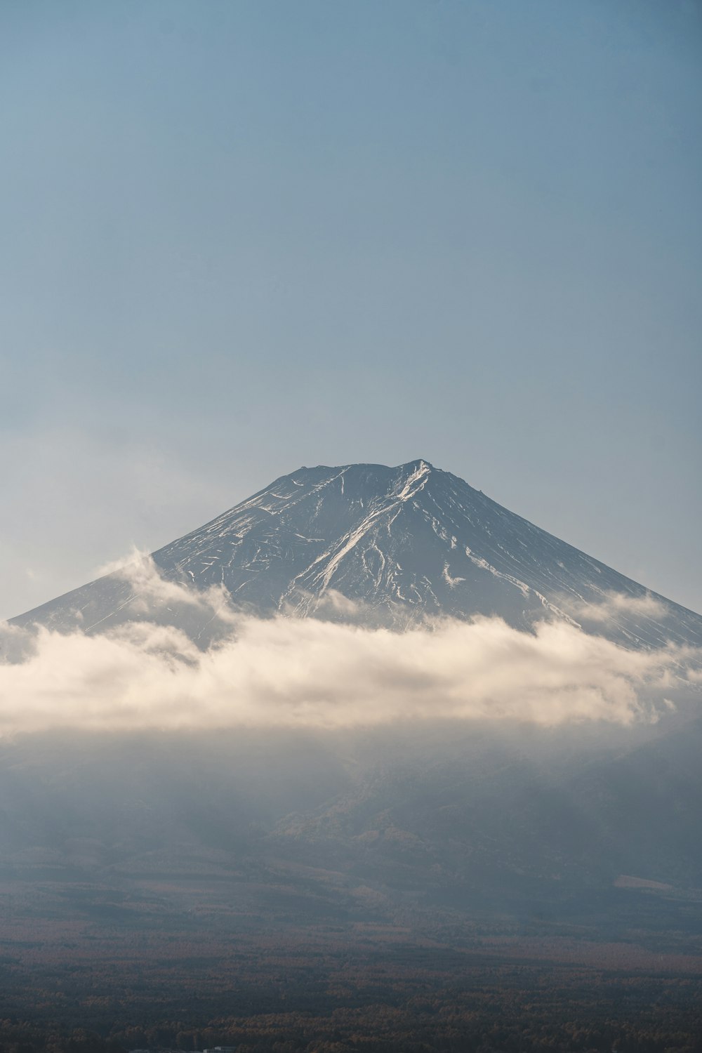 a mountain covered in a cloud covered sky