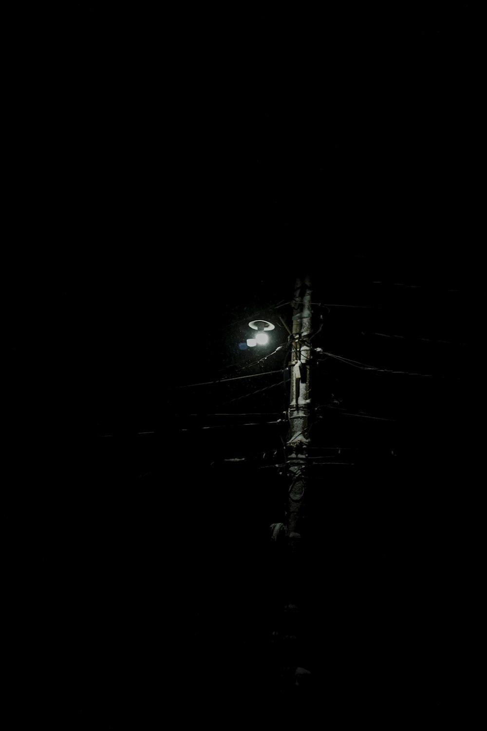 a street light sitting in the middle of a dark street