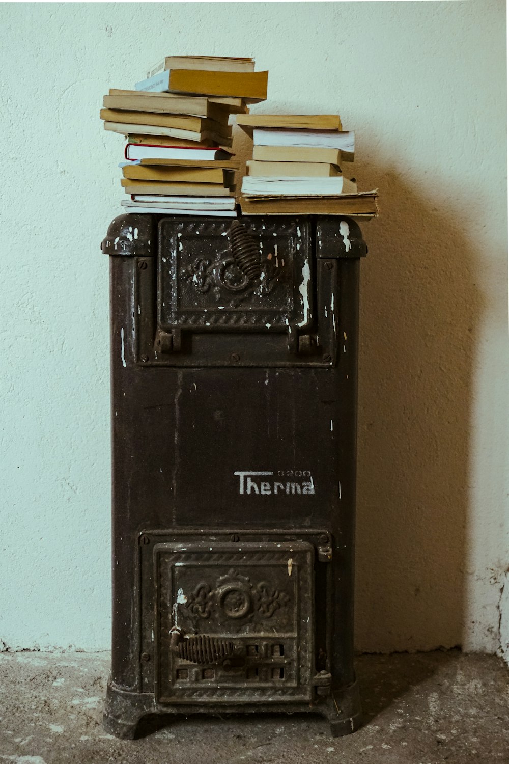 a stack of books sitting on top of an old stove