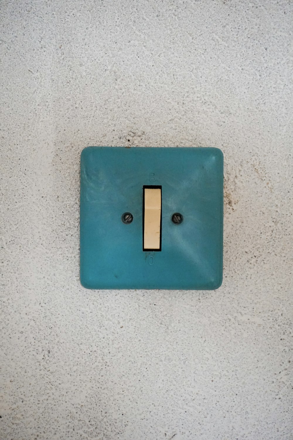 a blue light switch on a white wall