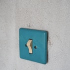 a blue light switch on a white wall