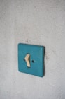 a blue light switch on a white wall